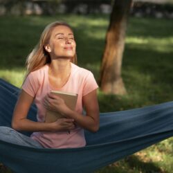 woman-sitting-hammock-holding-book